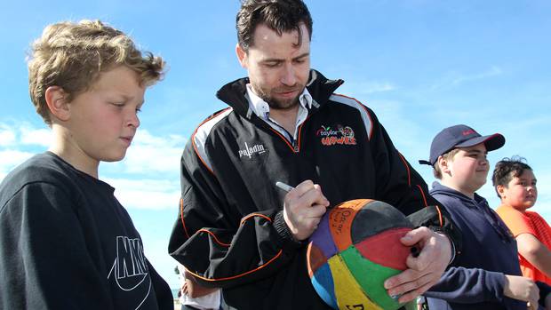 Zico Coronel signs basketball for a young fan